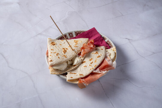 plate with piadina with raw ham and squacquerone