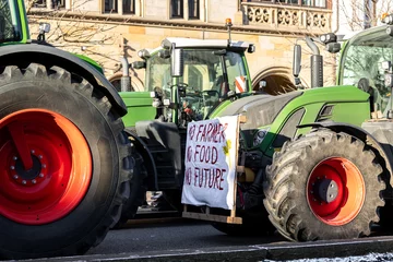 Tuinposter Farmers union protest strike against government Policy in Germany Europe. Tractors vehicles blocks city road traffic. Agriculture farm machines Magdeburg central Breiter weg street © Kirill Gorlov