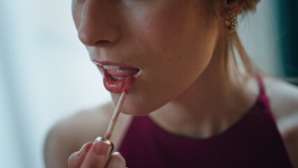Closeup brush applying lipstick. Romantic girl doing makeup admiring herself.