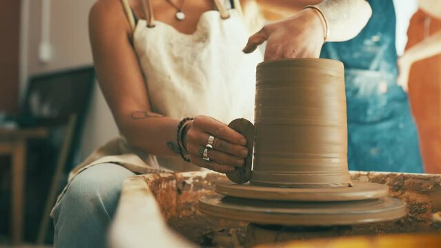 Woman, hands and clay for pottery, ceramics or mold in creativity, art or cylinder shape at workshop. Closeup of female person, sculptor or artist working on pot sculpture, craft or handmade startup