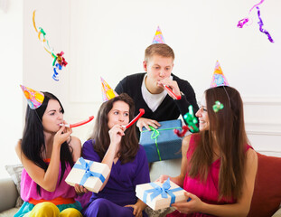 Obraz premium Joyful girl at birthday party surrounded by friends at party