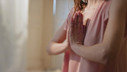 Closeup namaste hands doing yoga in morning. Peaceful woman practicing asana