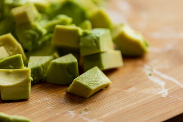 Cut Avocado Cubes Close Up on Wooden Board - Fresh and Tasty Slices