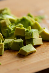 Cut Avocado Cubes Close Up on Wooden Board - Fresh and Tasty Slices