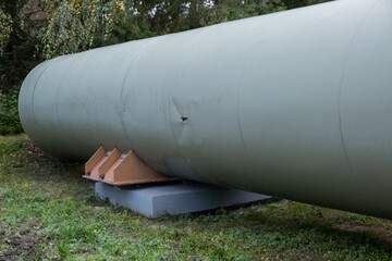 A colossal tube represents a thermal energy transfer infrastructure, central heating pipes enveloped in a robust metal thermal insulation jacket. Above-ground in European distribution energy