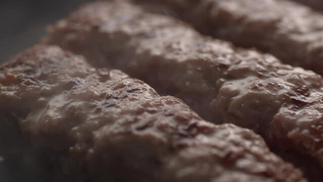 Grilling Cevapcici Sausages in Pan. Close-up, shallow dof.