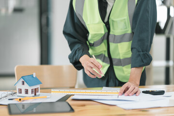 Professional male Construction Engineer Reviewing Blueprints on Worksite.