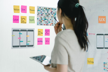 Asian ux designer evaluating app prototypes with color swatches. - obrazy, fototapety, plakaty