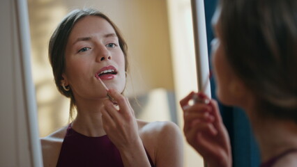 Gorgeous girl applying lipstick in mirror reflection closeup. Joyful model enjoy - obrazy, fototapety, plakaty