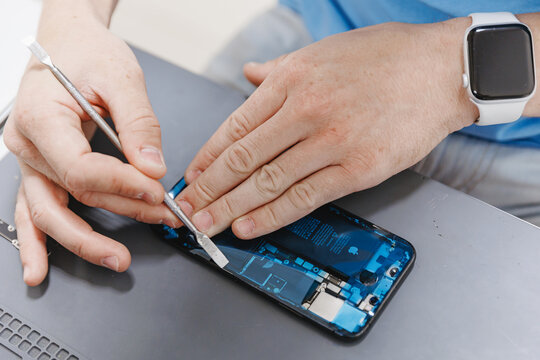 RUSSIA - July 26, 2023: Repair iPhone apple broken phone screen and replace used rechargeable batteries for recycling