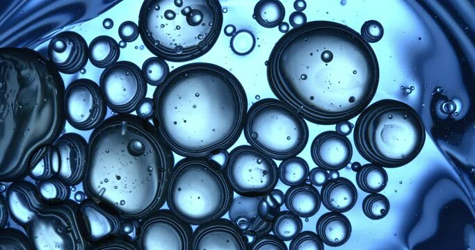 Slow motion macro of floating micro particles molecules in liquid are analyzed with microscope by chemist during innovative new medical research and analysis in scientific pharmaceutical laboratory.