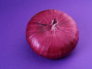 A red onion on a purple background.