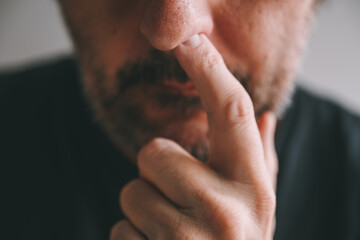 Closeup of male finger picking nose