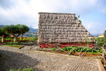 Traditional rural Madeirense farmhouse in Santana, built during the settlement of Madeira island in the Atlantic Ocean by the Portuguese. Is has sloping triangular rooftops, protected by straw