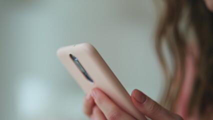 Closeup hands holding smartphone in dark room. Worried girl looking screen read - obrazy, fototapety, plakaty