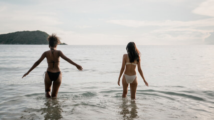 Happy girls enjoying freedom and walking on the beach. Summer holidays and vacation concept.