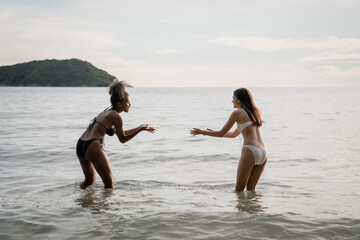 Happy girls enjoying freedom and walking on the beach. Summer holidays and vacation concept.