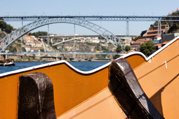 Fototapeta na wymiar Navigation on the Douro river, in the background the Luis I Bridge, one of the symbols of the city of Porto in Portugal.