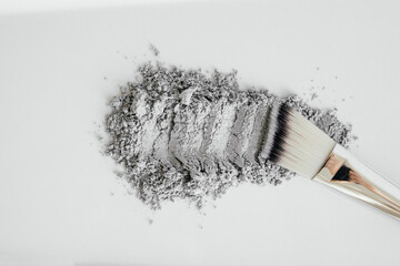 Cosmetics mask gray clay on a white background. Clay and Activated Charcoal Mask with brush....