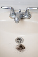 Messy clog hair in ceramic sink