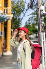 Asian woman backpacker traveler exploring the old city streets local community in Bangkok during a sunny day