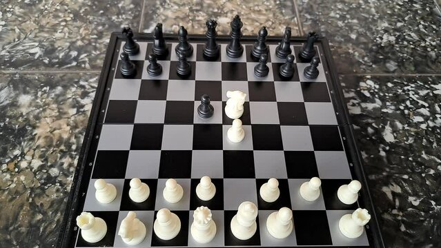 Video of a man's hand demonstrating a chess opening move.