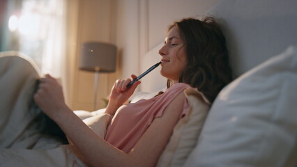 Smiling girl thinking ideas at home. Pensive calm woman making notes in diary