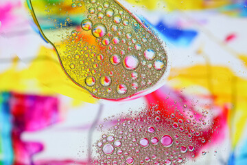 Macro shot of water-oil emulsion over colored background