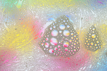 Macro shot of water-oil emulsion over colored background