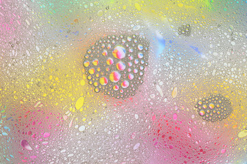 Macro shot of water-oil emulsion over colored background