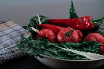 fresh chard leaves green ready to cook or salad with tomatoes and red pepper on dark background