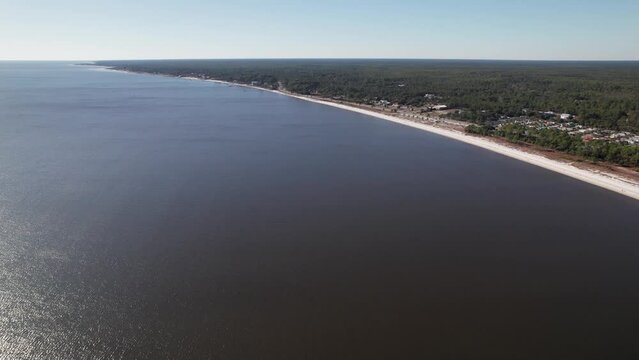 Drone shot and aerial view above water at Florida ocean and sea beach at coastline along the Gulf of Mexico south of Tallahassee in the deep south of the United States during winter