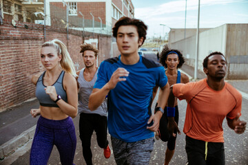 Group of diverse runners jogging on urban street