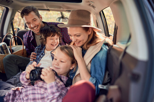 Family road trip with parents and children laughing in car