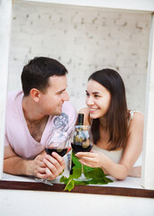 Young happy couple enjoying a glasses of red wine