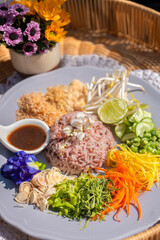 Fototapeta na wymiar Steamed rice with various herbs and vegetables mixed with Budu sauce. Thai Southern Spicy Rice Salad with Vegetables with Budu Thai southern styled fish sauce.