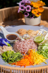 Steamed rice with various herbs and vegetables mixed with Budu sauce. Thai Southern Spicy Rice Salad with Vegetables with  Budu Thai southern styled fish sauce.