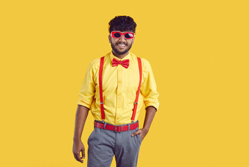 Young happy indian guy in funny party outfit and sunglasses in studio. Joyful indian man with...