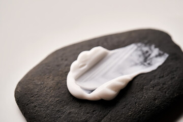 A smear of white cream on a black stone.