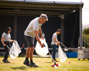 Volunteers Picking Up Litter After Outdoor Event Like Concert Or Music Festival - Powered by Adobe
