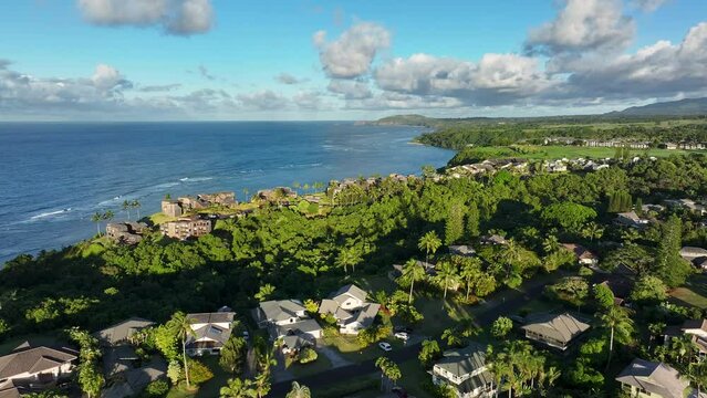 Aerial Kauai Princeville resorts ocean afternoon evening. Expensive luxury homes, resort, condominium and golf club near coast. Recreation and tourism. Economy tourism. Warm tropical climate.