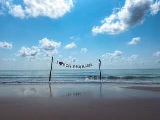Landscape photograph of Haad Rin beach on Koh Phangan, Thailand. Sign reads I love Koh Phangan. 