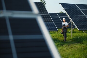 A handyman standing with solar panels.