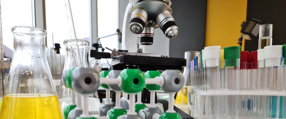 Microscope with many test tubes and a plastic molecule