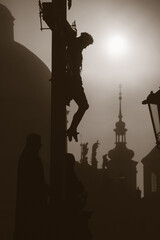 Prague - The cross from H. Hilger 1629 on the Charles bridge by sunrise - silhouette