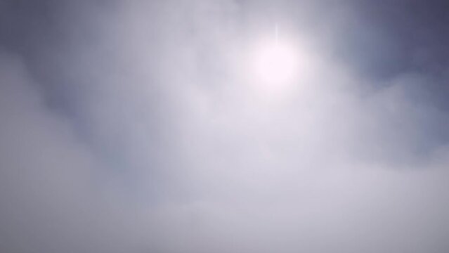 4K.Aero video shooting. Fly above the clouds and the sun in the sky, in a mountainous area. Amazing flyover through clouds with beautiful light on a fixed wing FPV drone