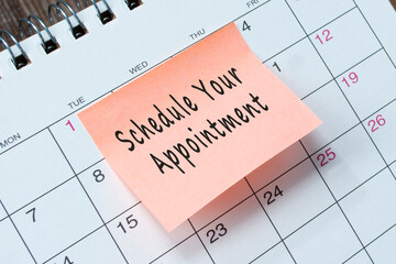 Schedule your appointment text on orange paper sticky note.