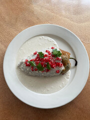 Chile en nogada: Stuffed poblano pepper with meat, fruit, nuts, creamy walnut sauce—Mexico's patriotic delight!