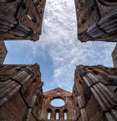 Fototapeta premium Missing ceiling opening the view to the sky in the destroyed abandoned Cistercian monastery San Galgano in the Tuscany