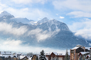 Cityscape of Brianson, ski resort in France. Mountain covered with snow and fog. Alpine landscape in Europe.
